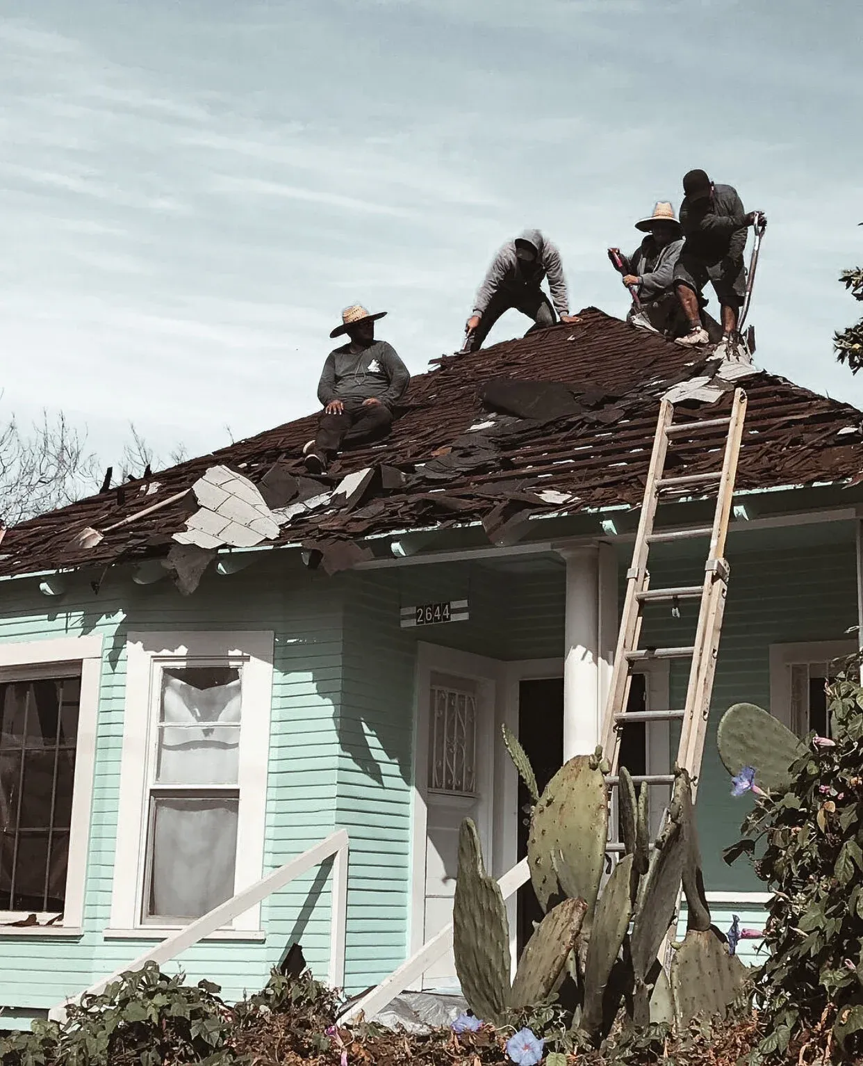 Chavez Roofing crew tearing off an old roof on a craftsman home